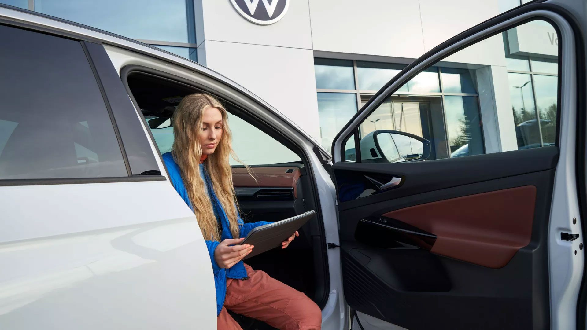Жена седи при отворена врата в VW ID.
