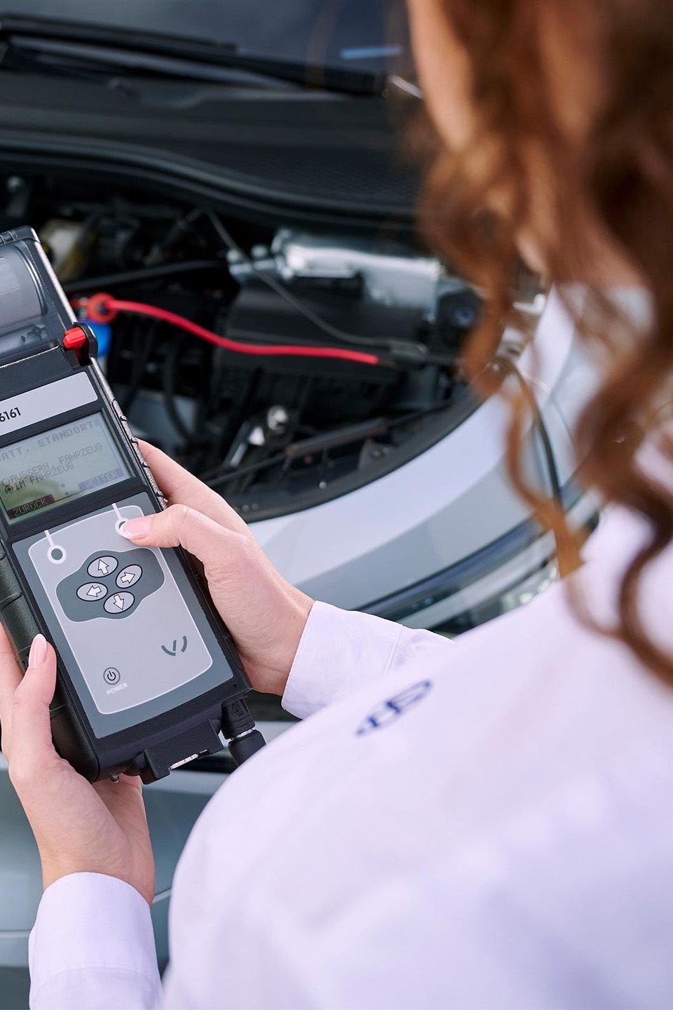 Eine VW Technikerin beim Elektroautoservice für einen Volkswagen ID