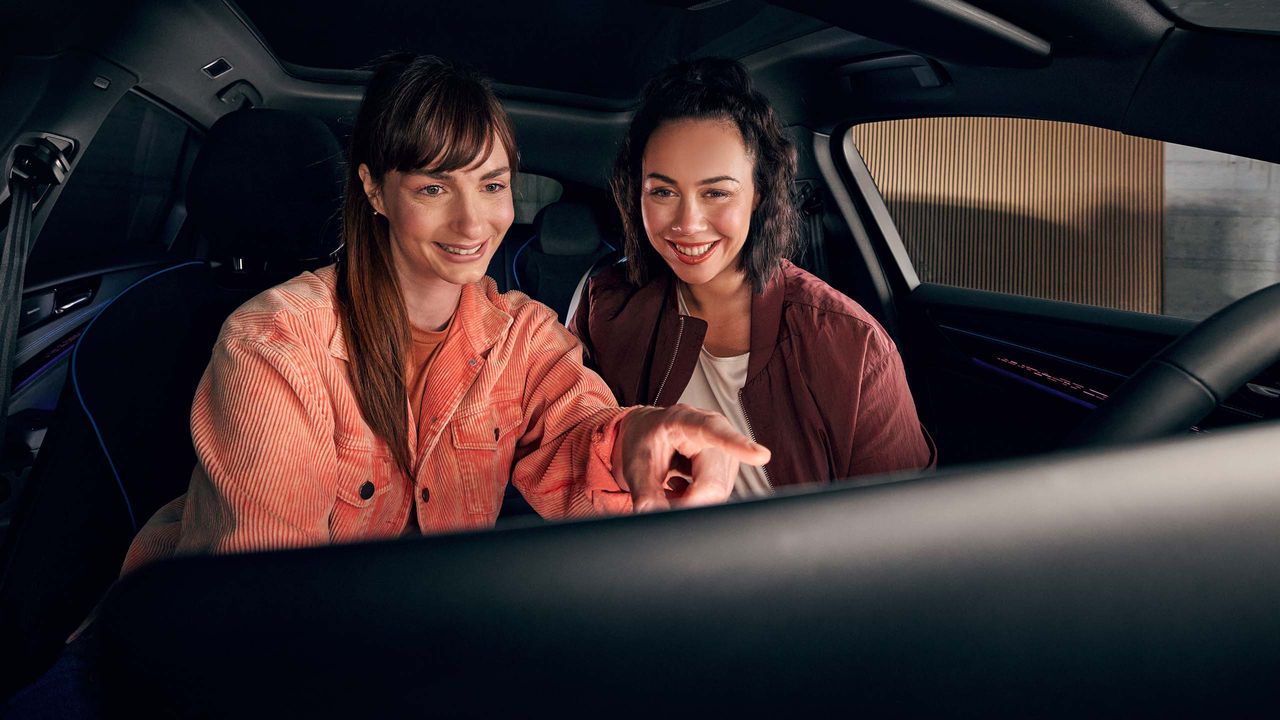 Две жени използват инфотейнмънт системата в колата VW