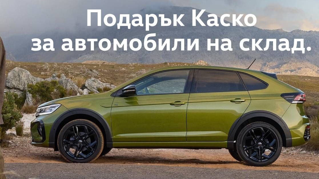 Зеленикав кросоувър VW Taigo е паркиран в планински пейзаж с облачно небе. Над него е изписан текст на български: „Подарък Каско за автомобили на склад.“ Рекламно изображение, подчертаващо промоционална застраховка за налични автомобили.