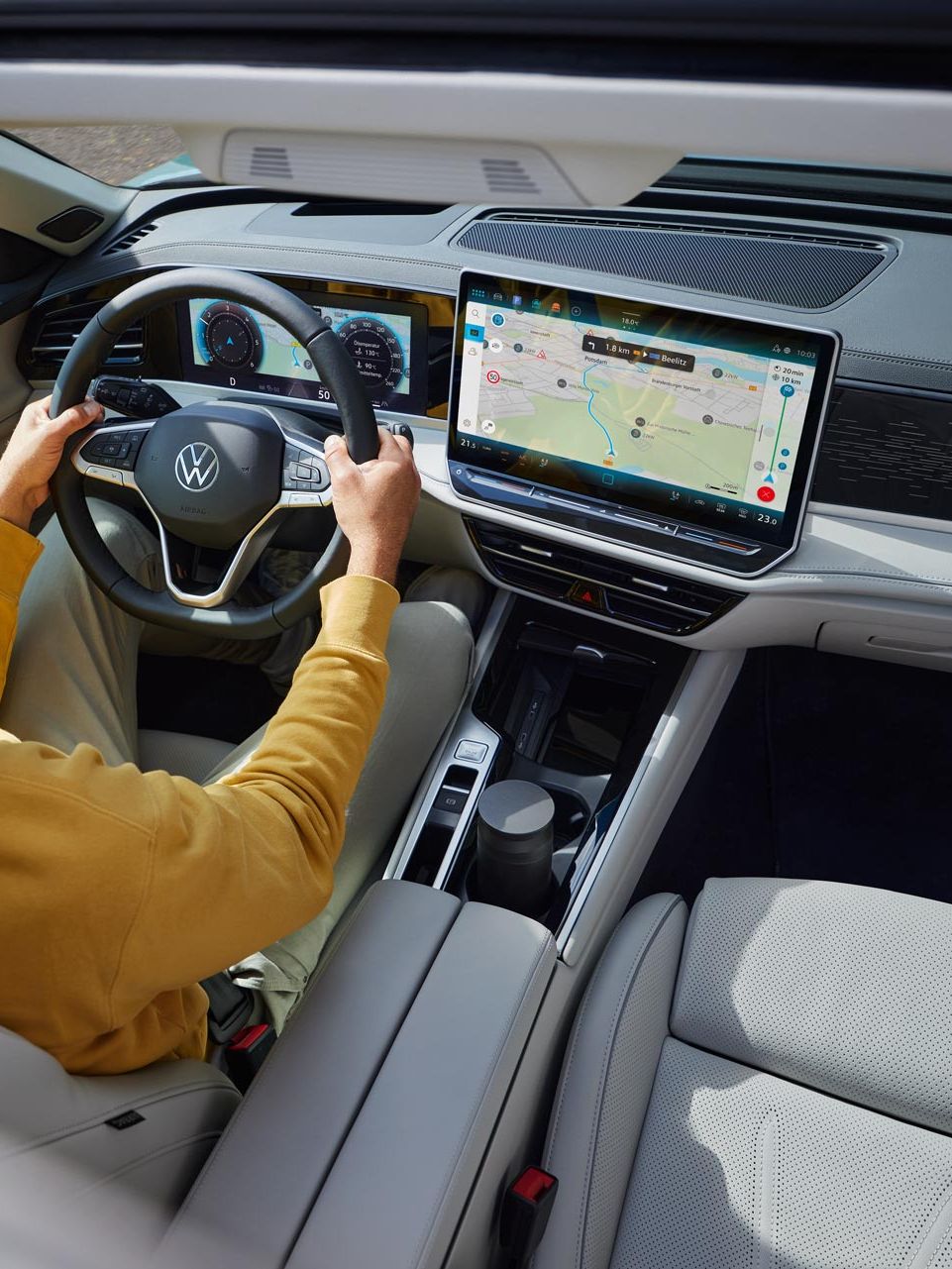 Поглед отгоре през отворения опционален шибедах на VW Passat, в който седи мъж с две ръце на волана.
