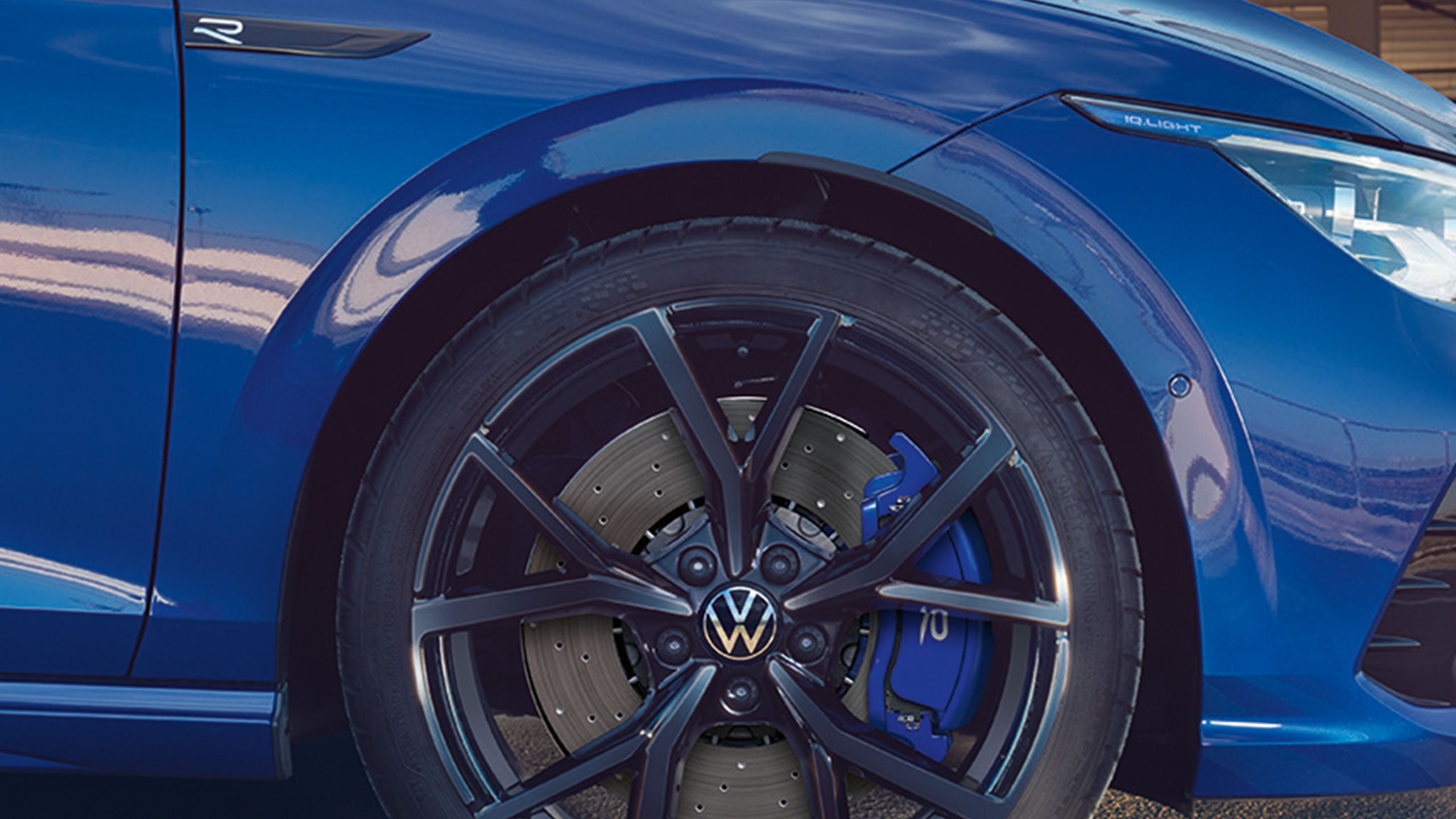 Близък план на черни джанти и сини спирачни апарати на син Volkswagen Golf R