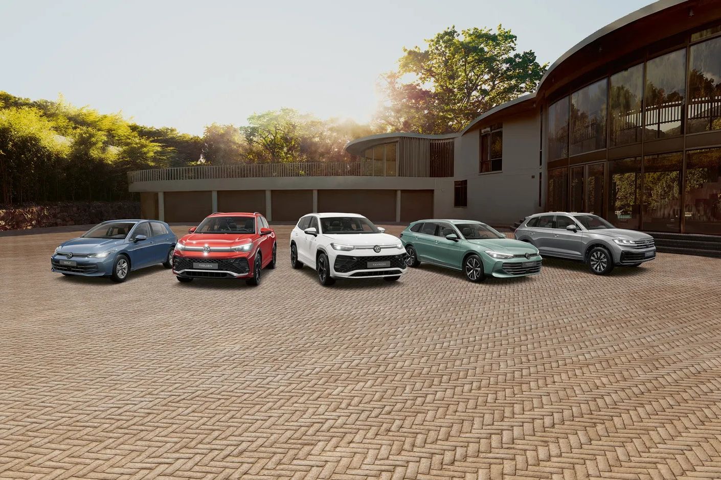 Гама модели на Volkswagen – от компактни до SUV автомобили, подредени пред модерна сграда при залез