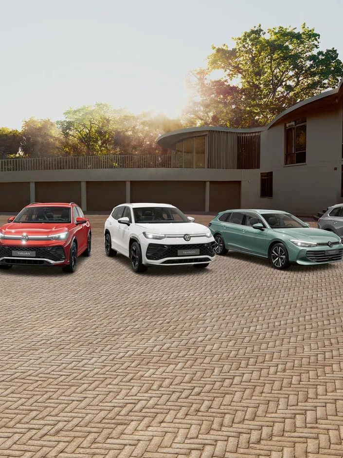 Гама модели на Volkswagen – от компактни до SUV автомобили, подредени пред модерна сграда при залез