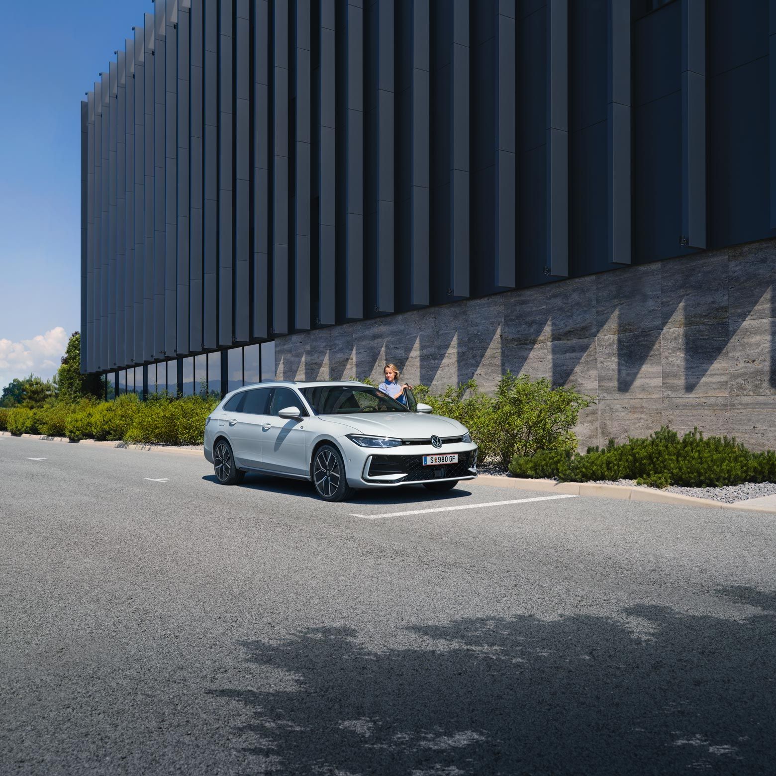 VW Passat в бял цвят паркира отстрани на сграда.