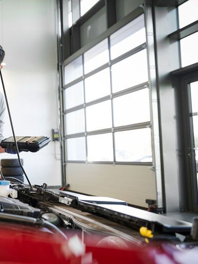 Volkswagen Service Technikerin vor geöffneter Motorhaube