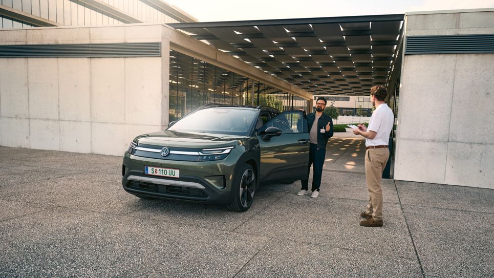 Мъж влиза в VW ID. Cross и разговаря с инженер с клипборд в ръка.