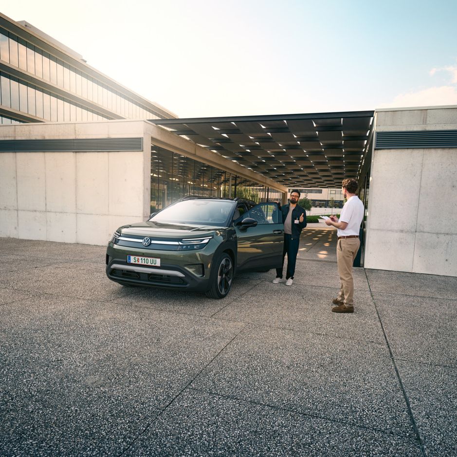 Мъж влиза в VW ID. Cross и разговаря с инженер с клипборд в ръка.
