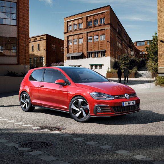 Червен Volkswagen Golf GTI, заснет отпред под ъгъл в модерна градска обстановка