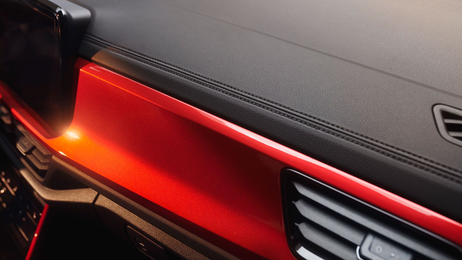 Detail der Ziernähte im Cockpit des VW T-Roc Cabriolets mit rotem Dekor.