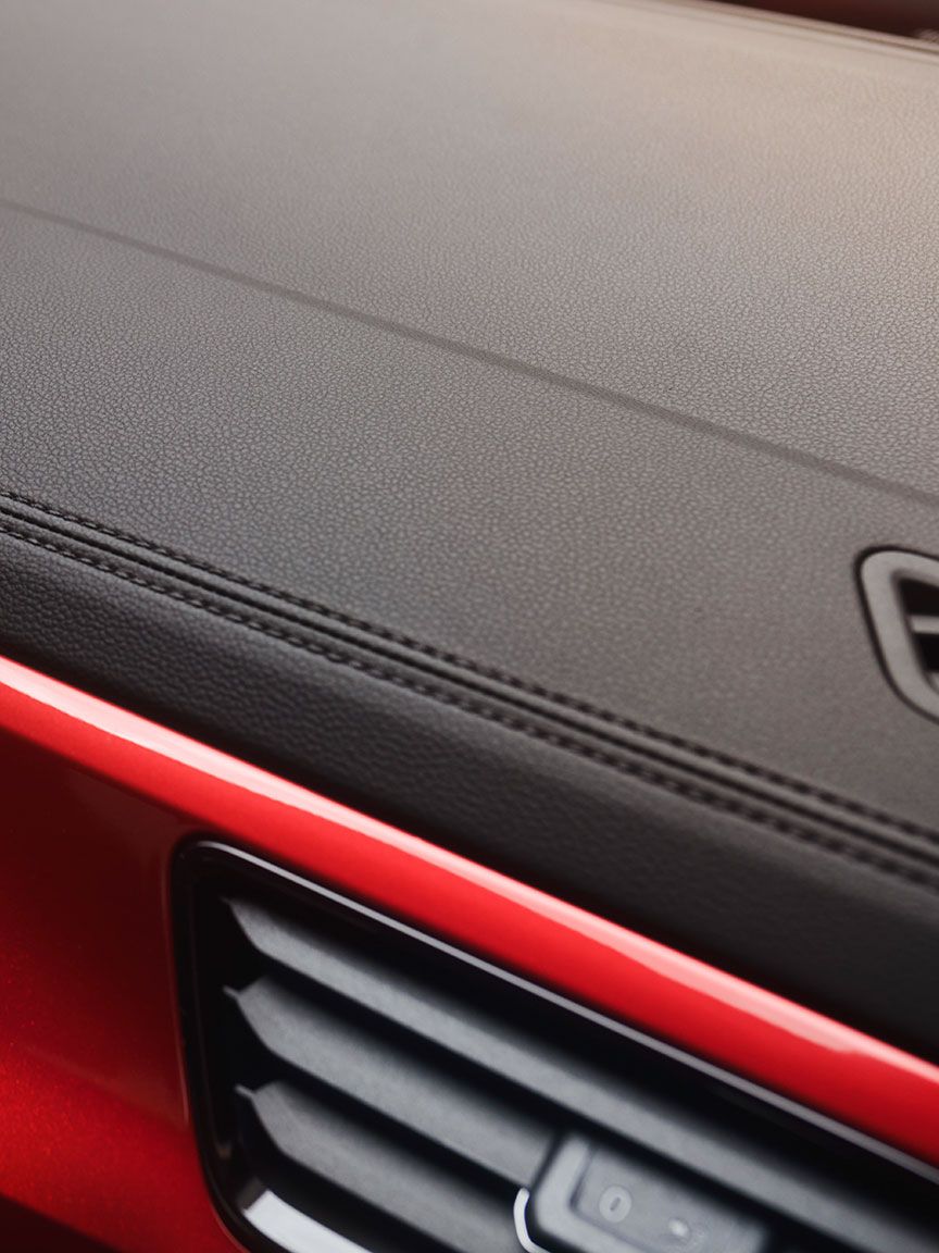Detail der Ziernähte im Cockpit des VW T-Roc Cabriolets mit rotem Dekor.