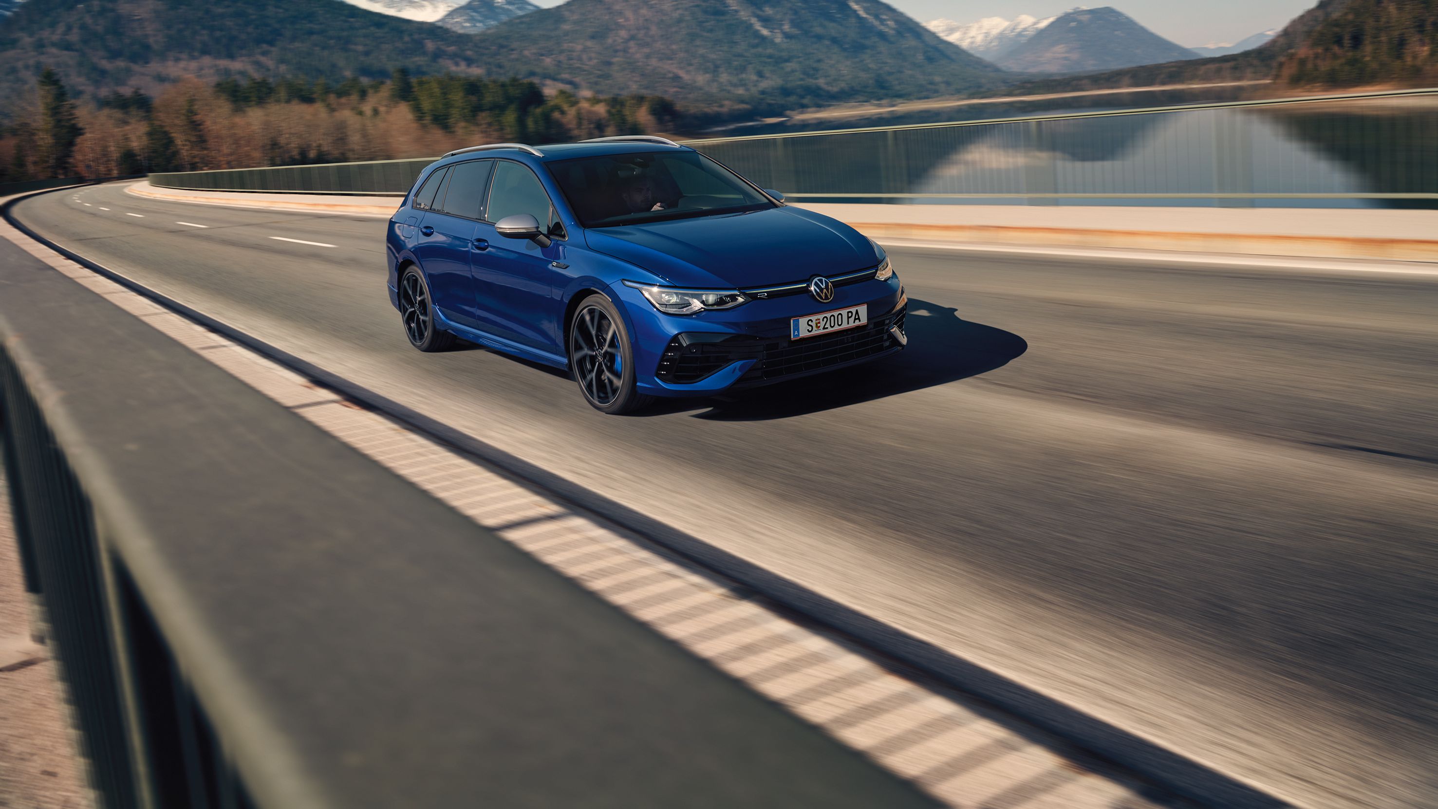 Син Volkswagen Golf Variant R в движение по живописен планински път