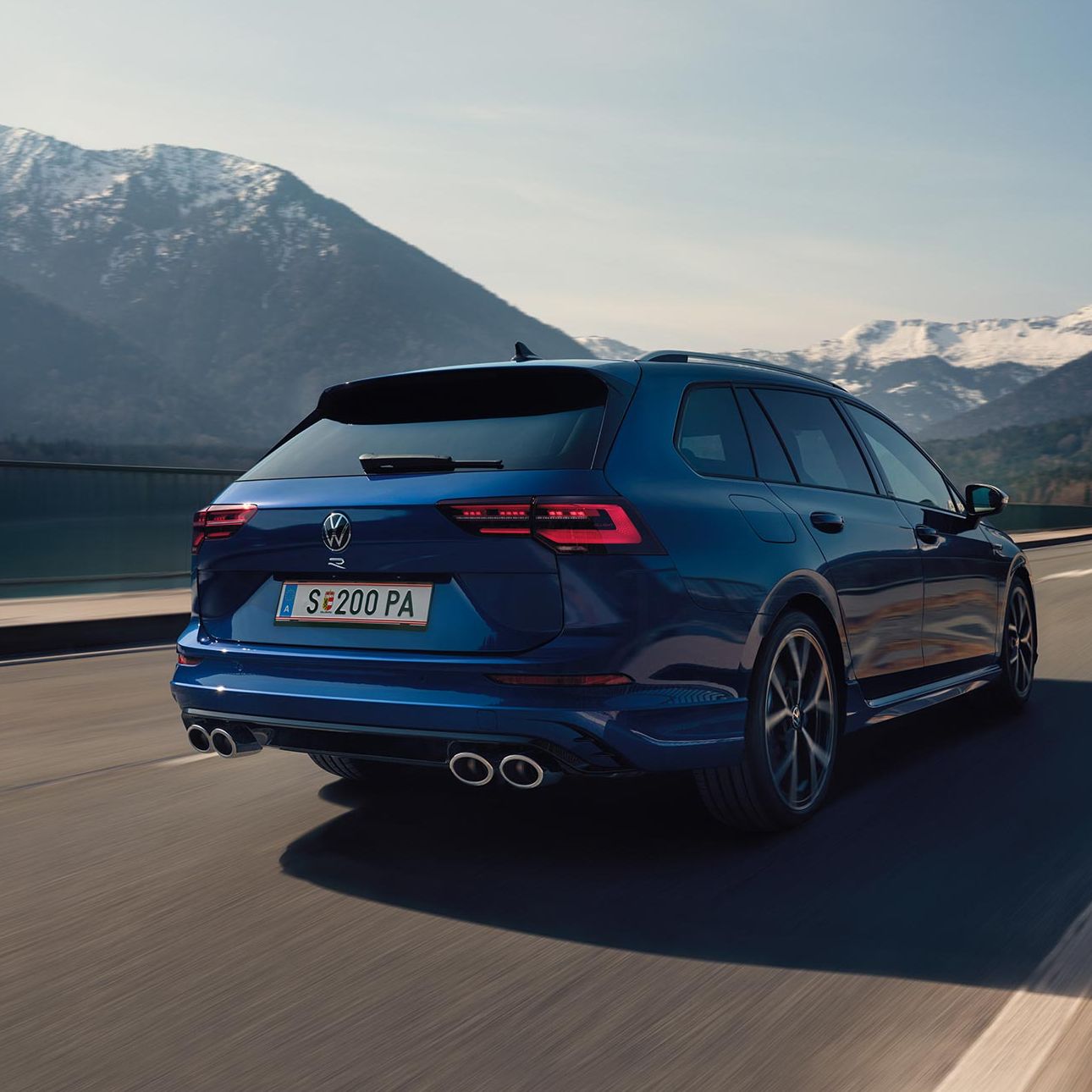Задна част на син Volkswagen Golf Variant R в движение по планински път 
