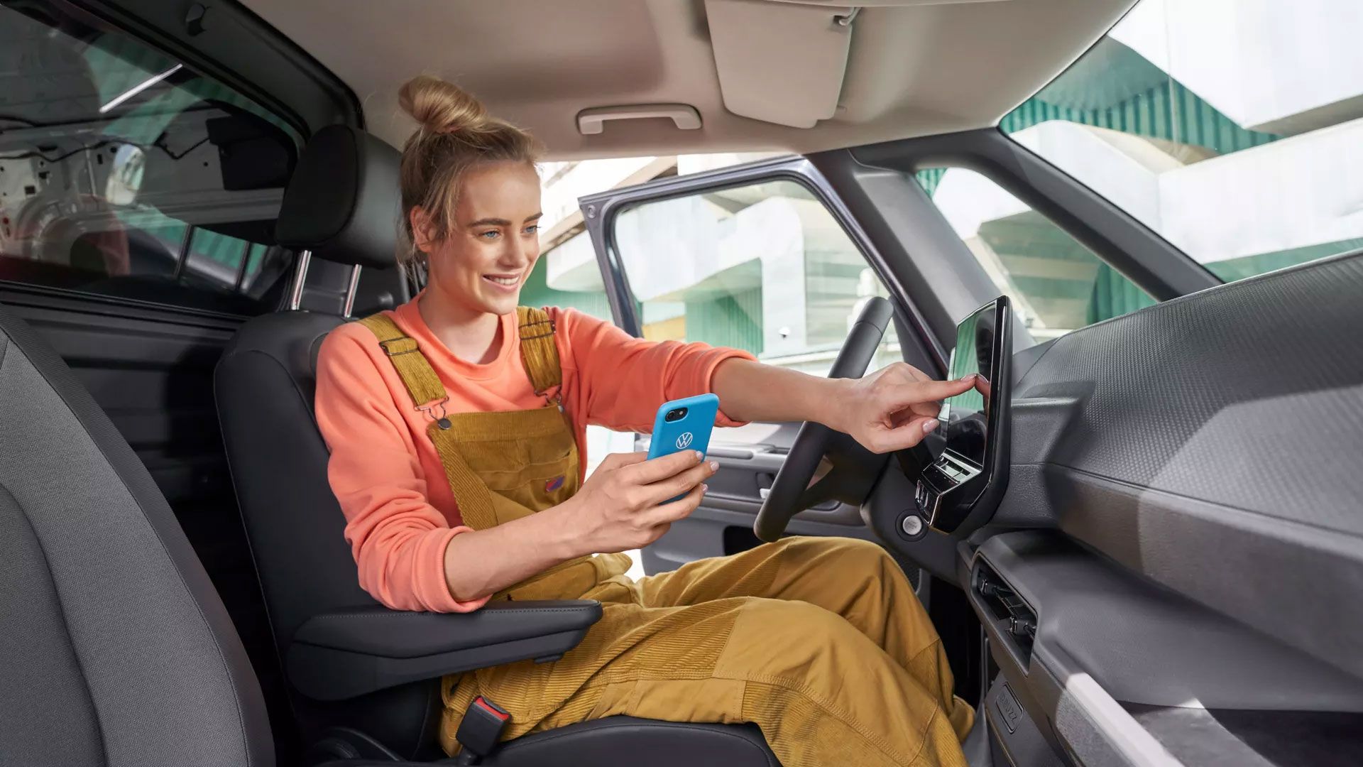 Жена седи в VW ID. и избира менюта от инфотеймънт системата