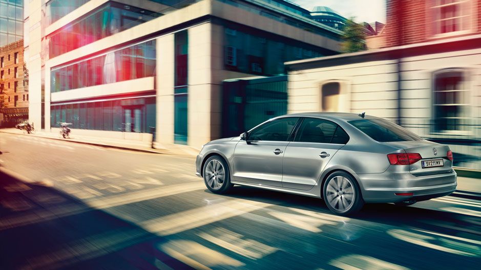 Сребрист Volkswagen Jetta в движение по градска улица