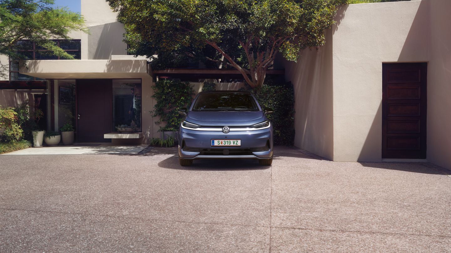 Син VW ID.3 Neo, паркиран пред еднофамилна къща