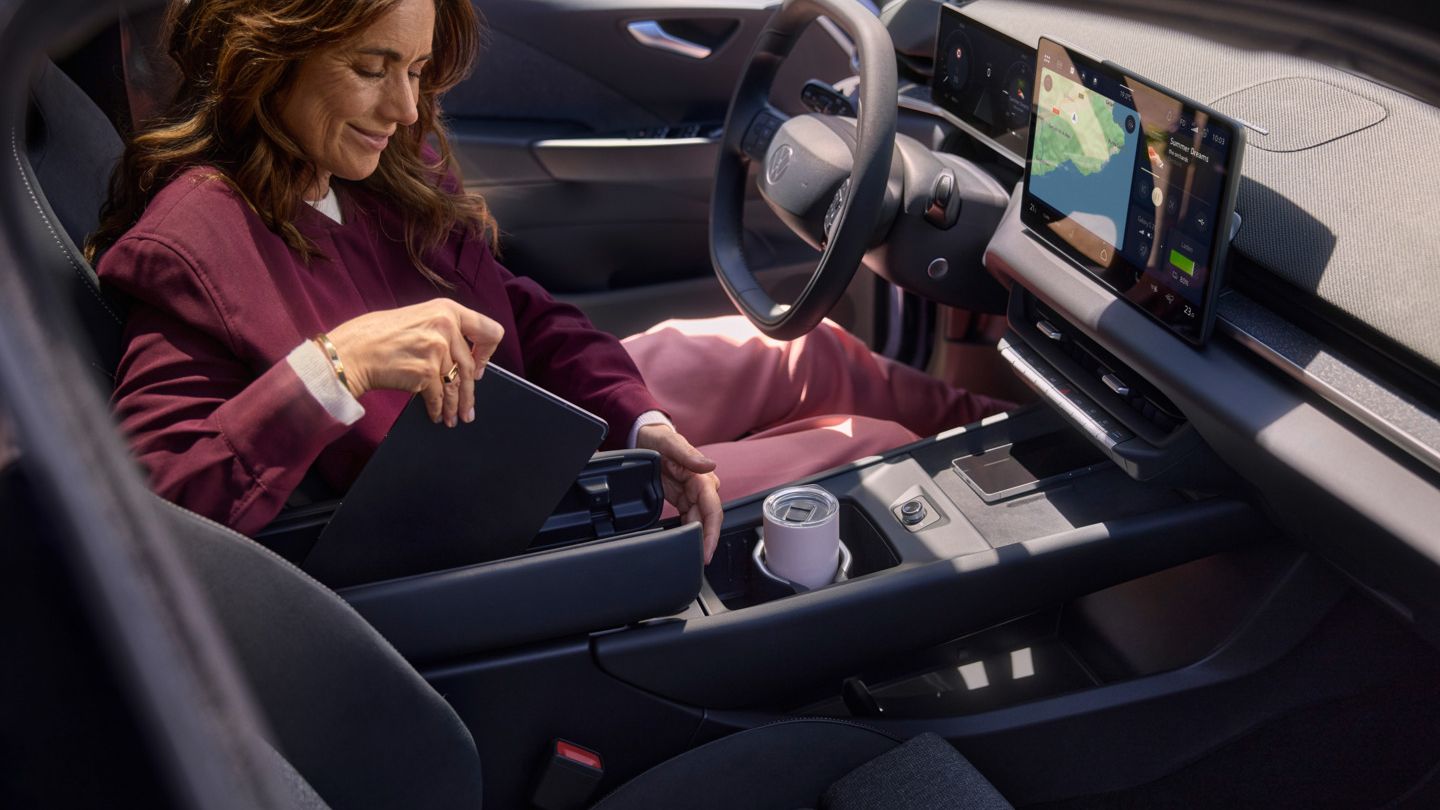Жена прибира таблет в VW ID.3 Neo в централната конзола с подлакътник тип пеперуда