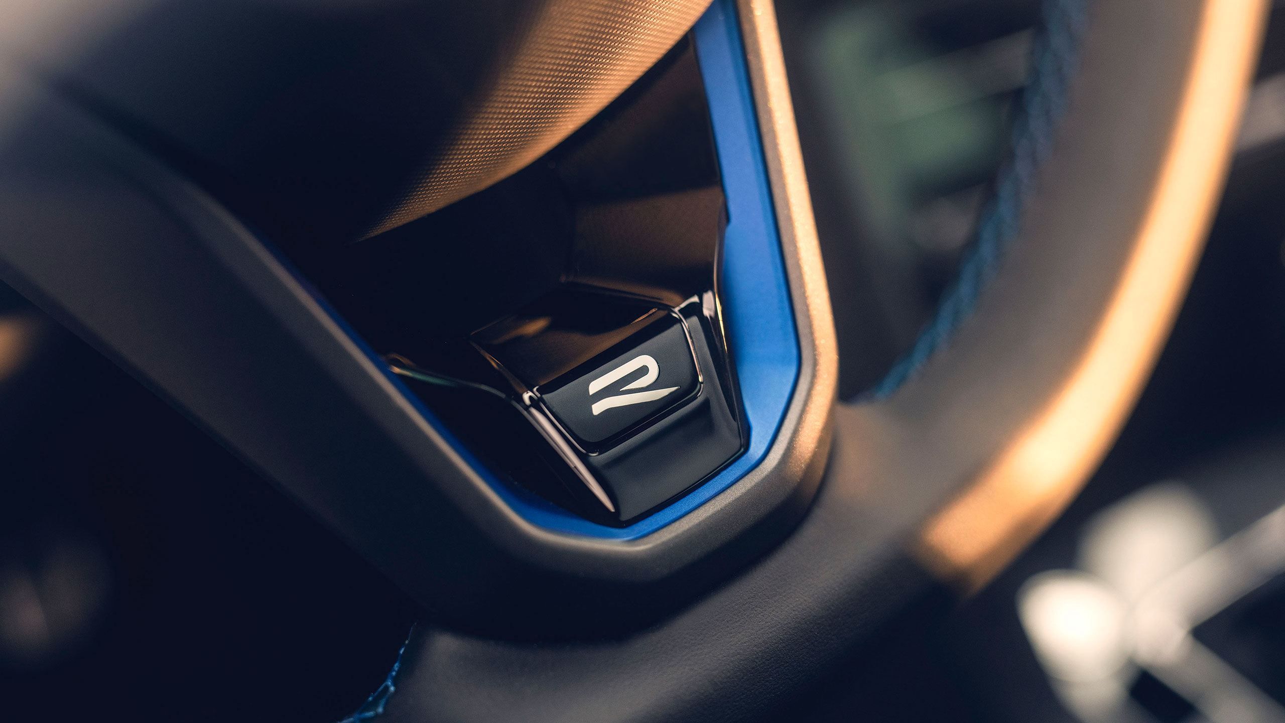 Детайл на R-Line бутон за спортен режим върху волана на Volkswagen Tiguan.