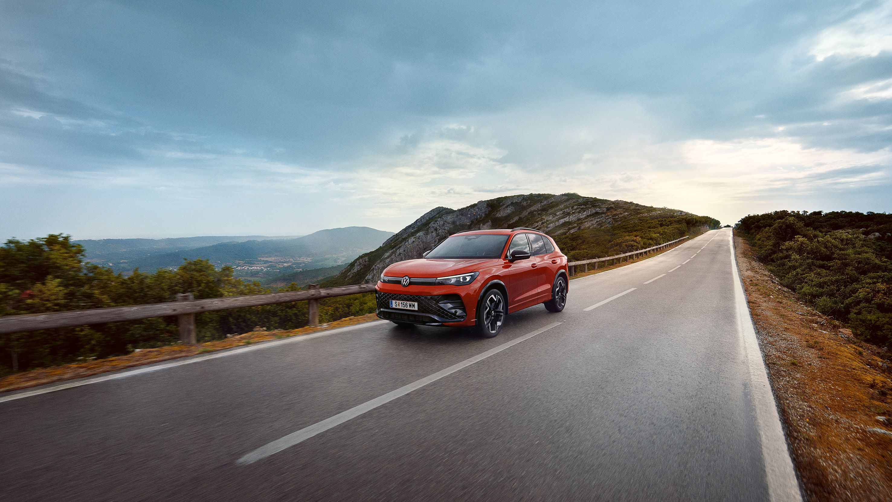 Червен VW Tiguan се движи по път.