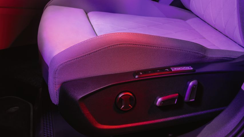 Интериор на Volkswagen Golf с акцент върху комфортната ергономична седалка и амбиентно осветление в лилаво-червени нюанси