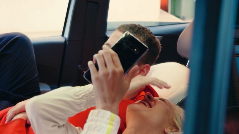 Млада двойка седи и се смее във Volkswagen ID.3 със сгънати седалки.