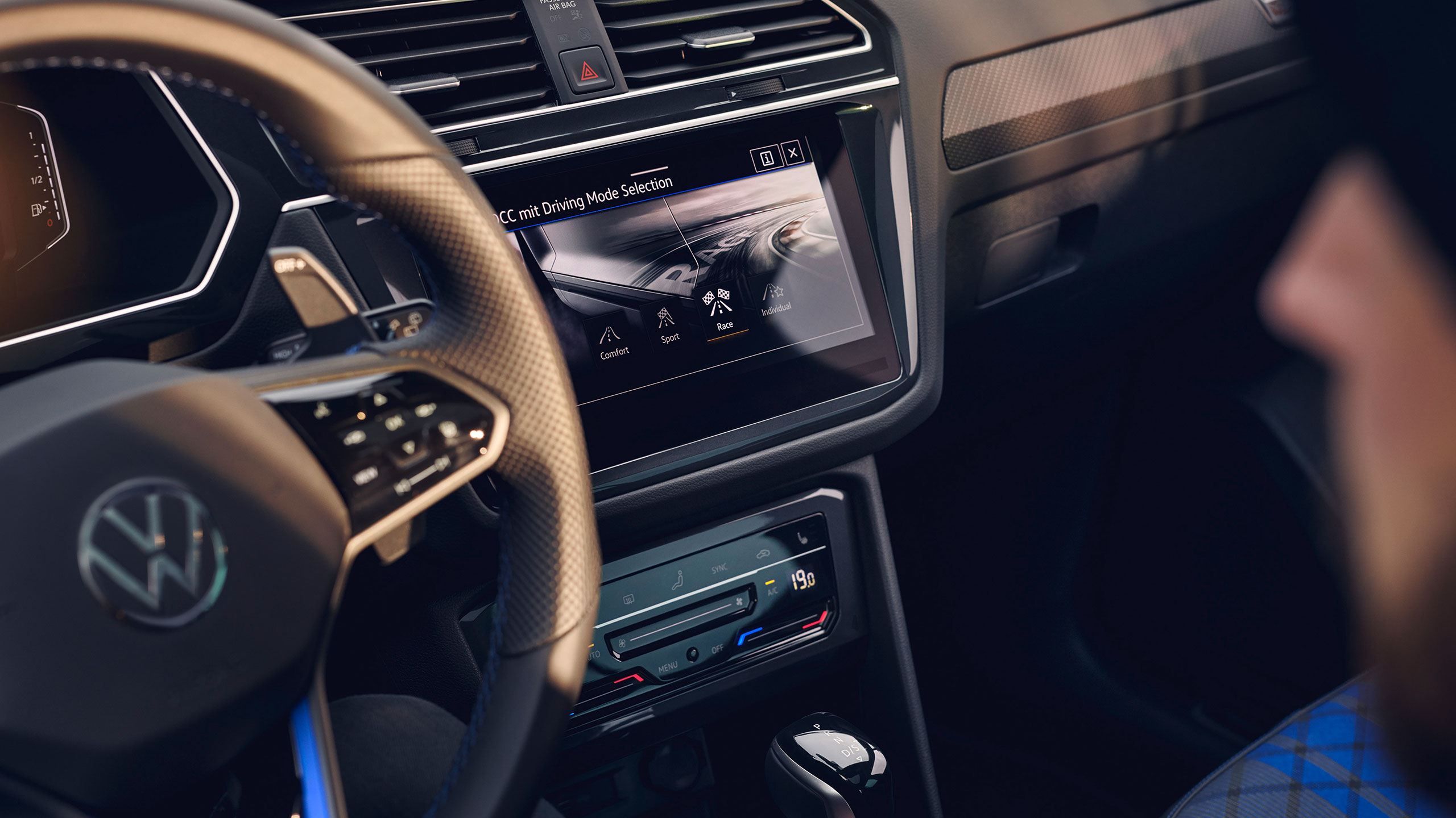 Близък план на мултимедийния дисплей във Volkswagen Tiguan с активирано меню за избор на режими на шофиране – Comfort, Sport, Race и Individual.