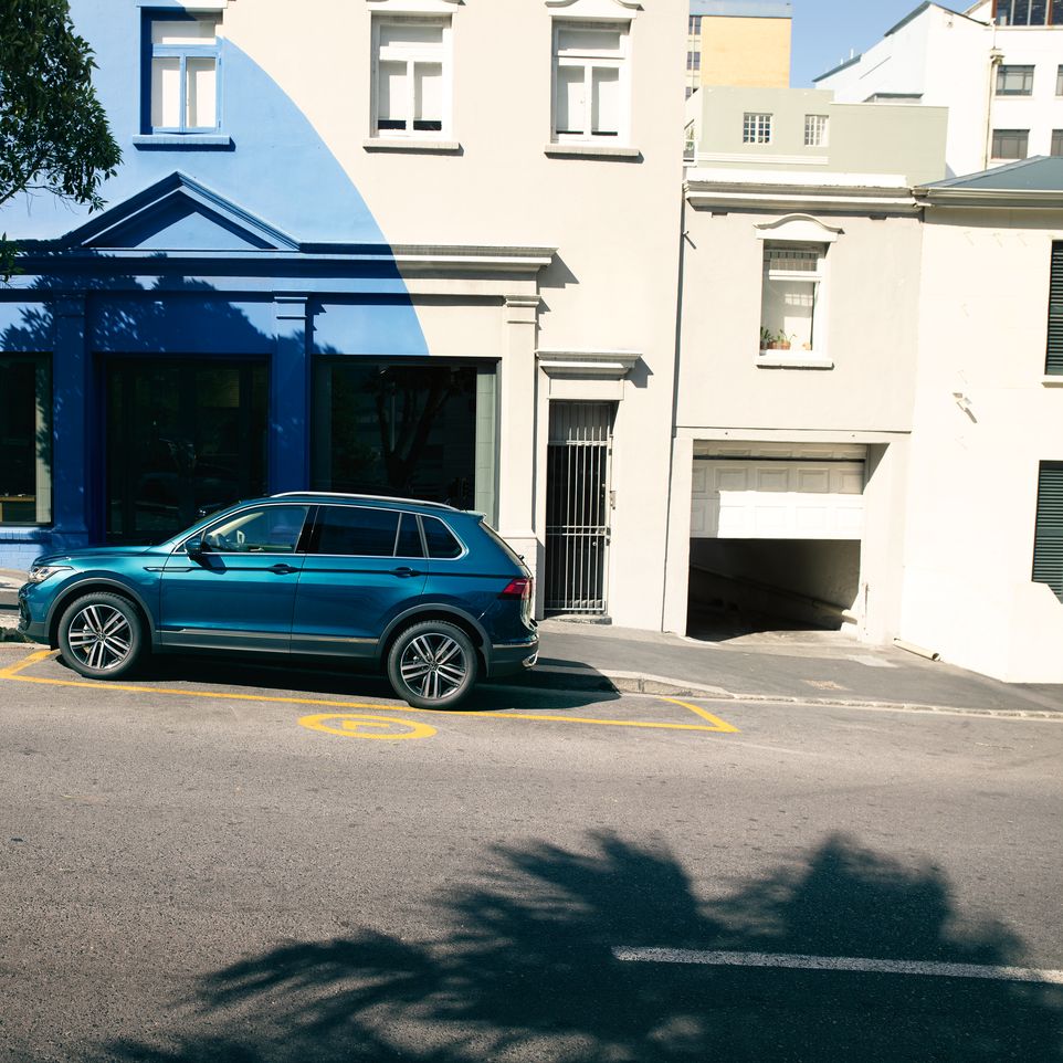 Blauer VW Tiguan parkt entlang einer Straße