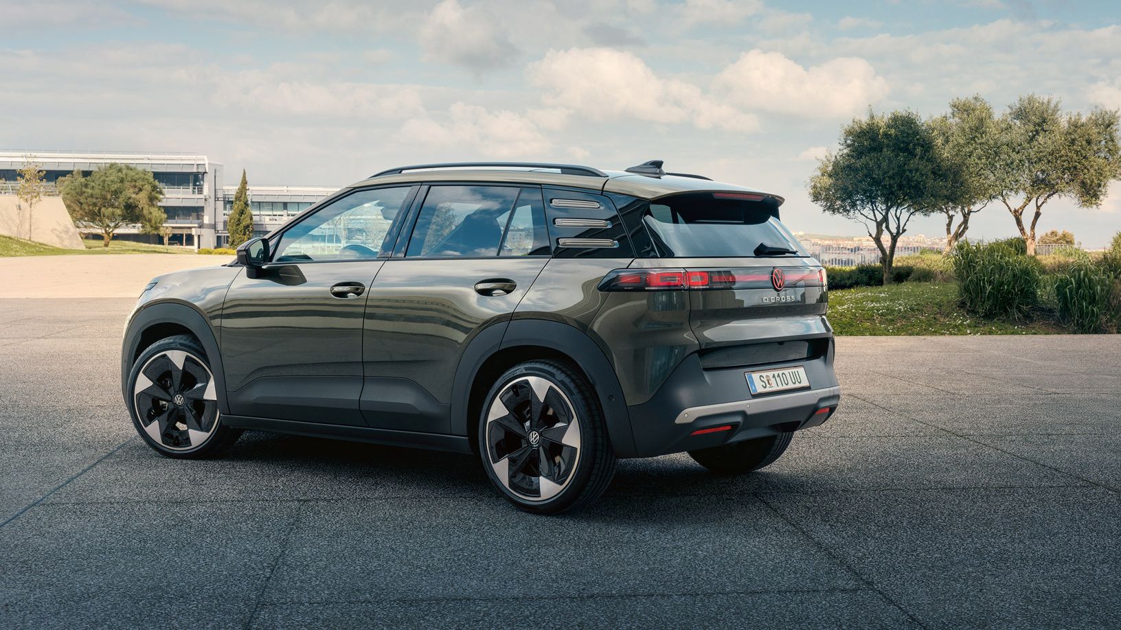 Изглед отзад на зелен VW ID. Cross, паркиран на площад със зелени дървета.