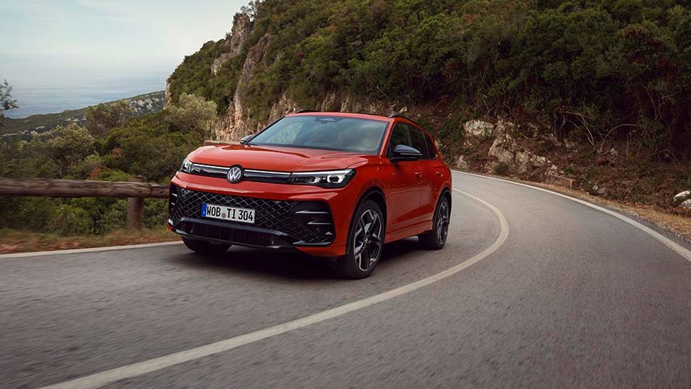Новият Volkswagen Tiguan R-Line в червен цвят, заснет в движение по планински път