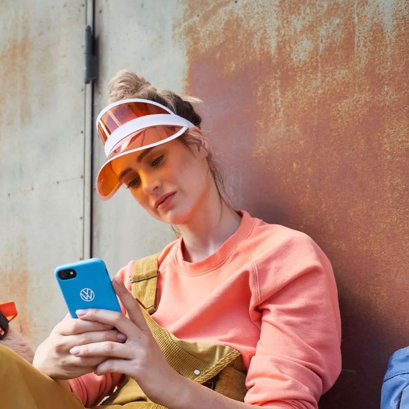 Eine Frau blickt auf ihr Smartphone, ein Hund ist bei ihr