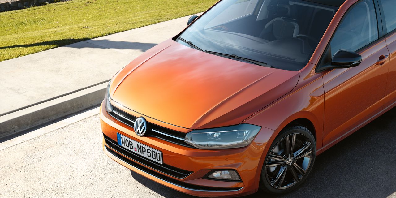 Оранжев Volkswagen Polo с черен покрив, паркиран на слънчев път